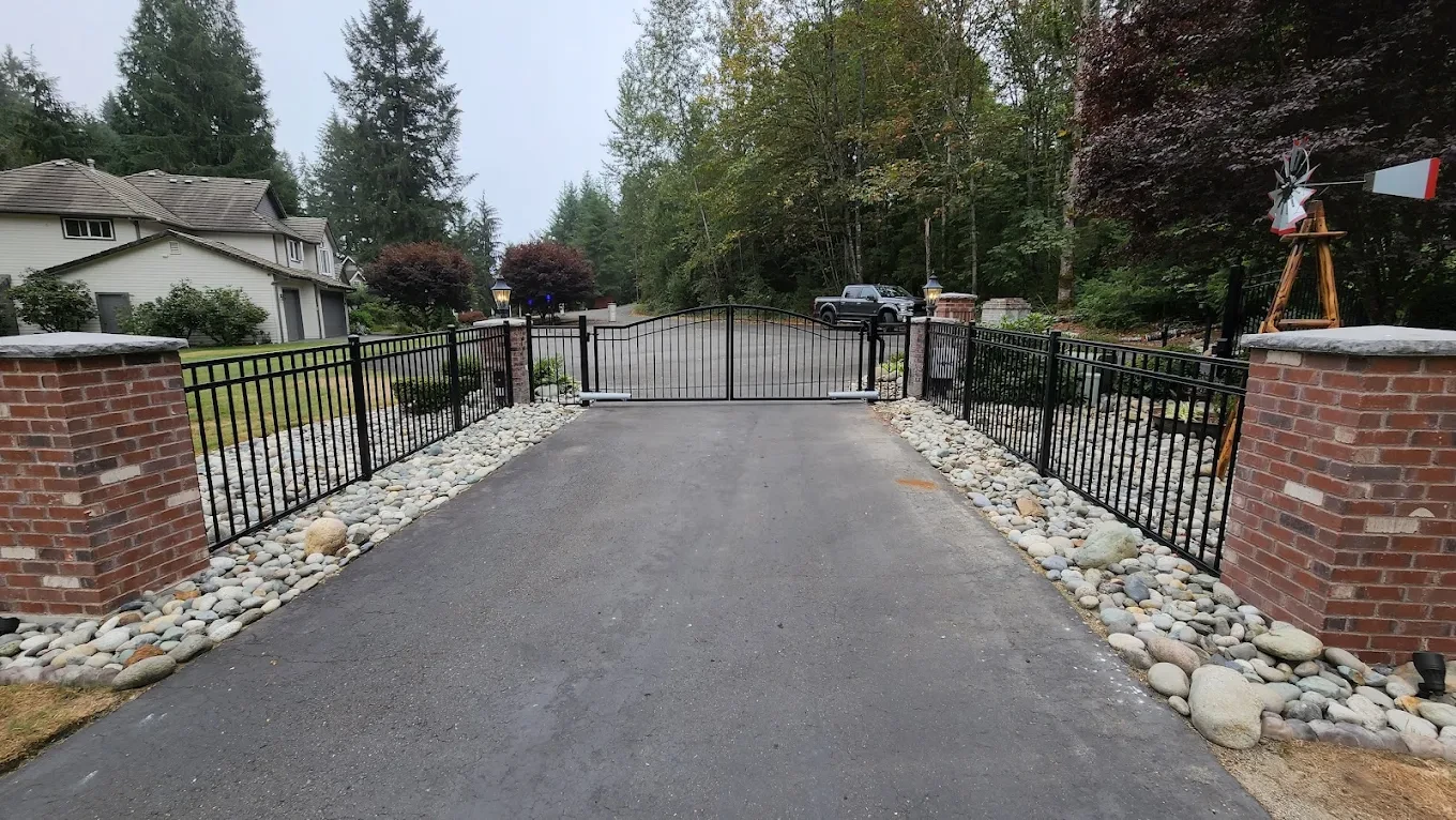 Driveway gate with brick pillars and trees
