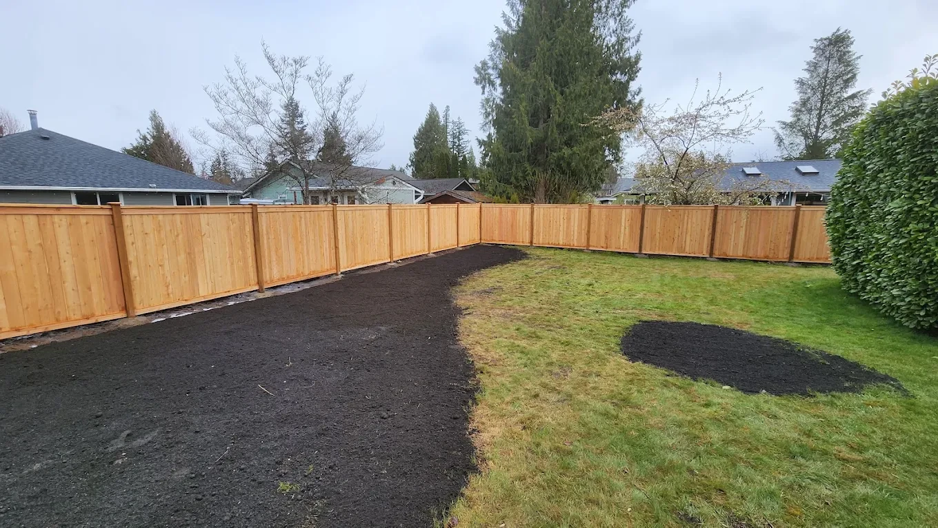 Fenced backyard with mulch and grass