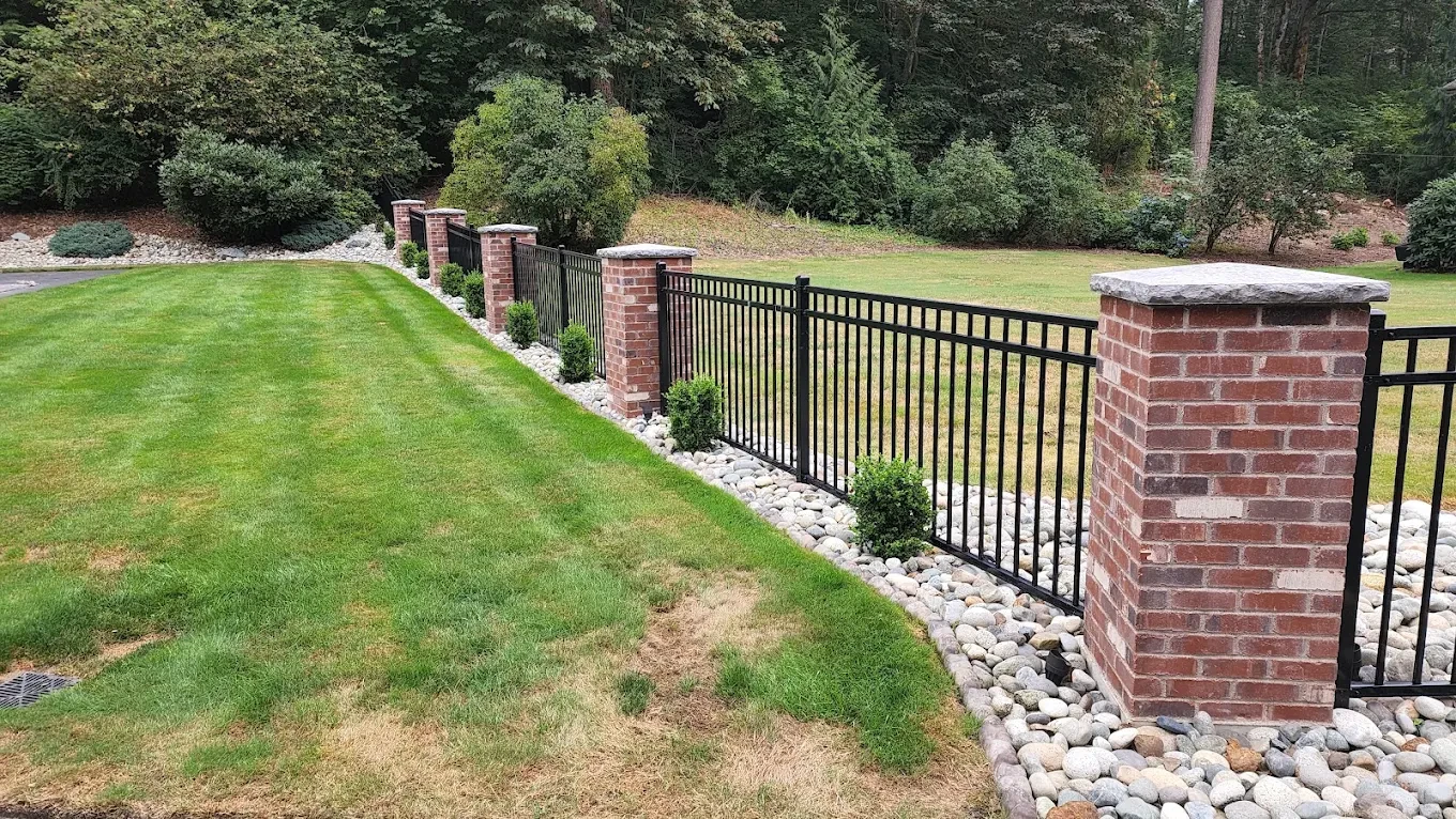 Brick fence with metal gate lawn